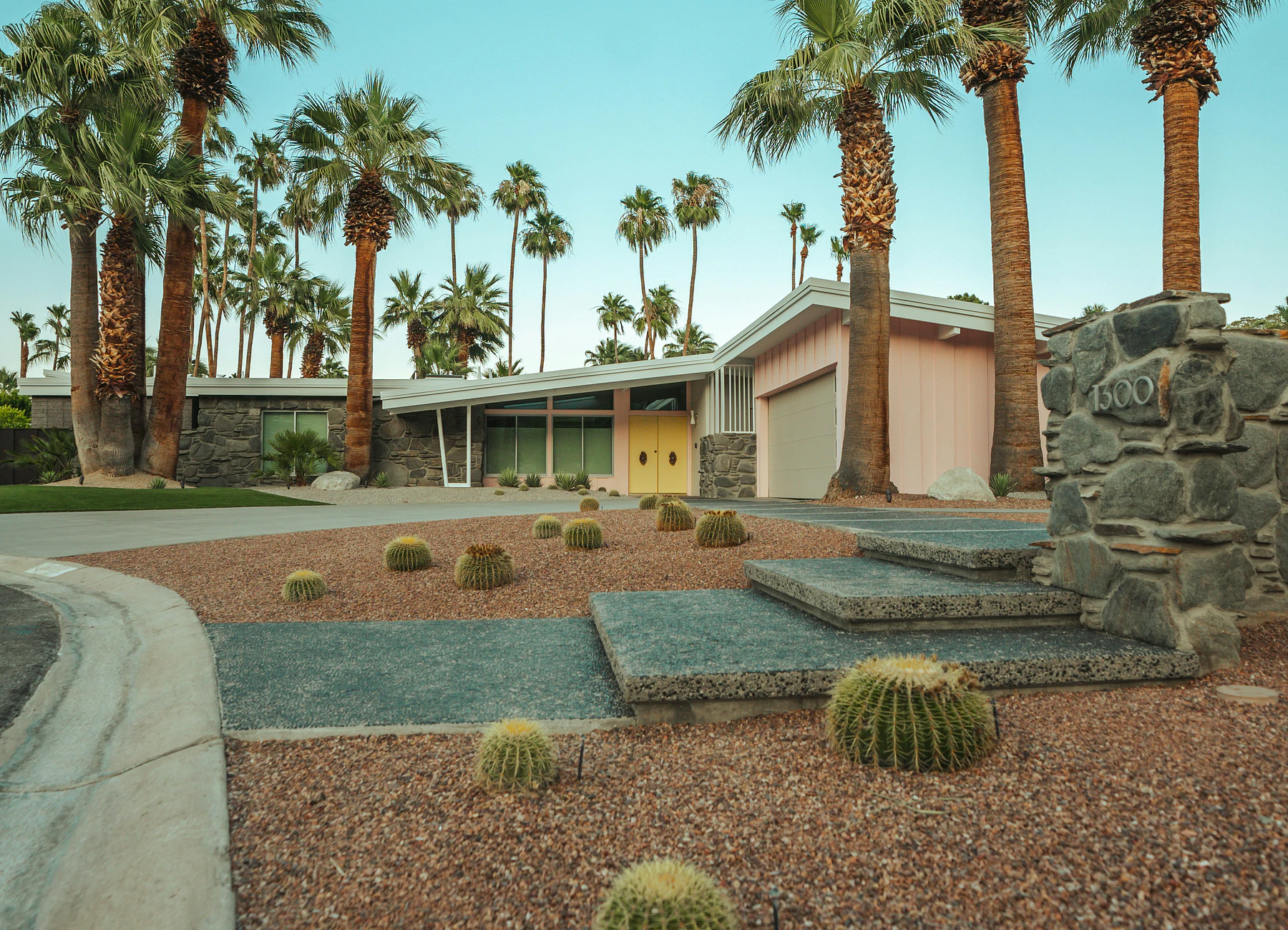 Mid-century Palm Springs home framed by palms and desert landscaping